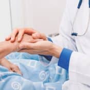gros plan sur les mains d'un médecin tenant les mains d'un patient dans un lit d'hôpital