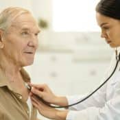 une médecin examine un homme âgé avec un stéthoscope
