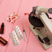 table sur laquelle se trouvent un microscope, et des médicaments